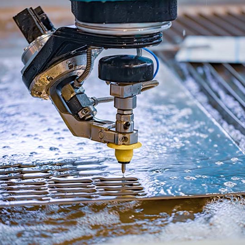Water jet machine cutting out a part from a piece of material